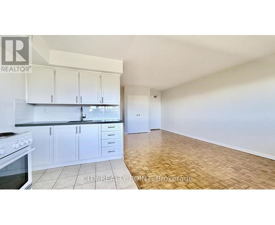 A kitchen with white cabinets and a stove top oven.