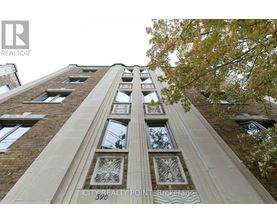A tall building with a row of windows and decorative panels on the front.
