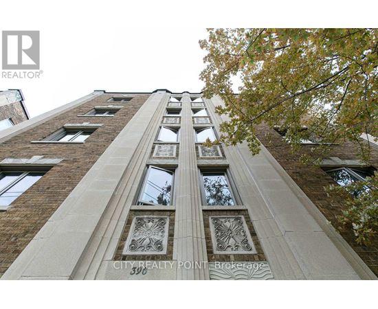 A tall building with a row of windows and decorative panels on the front.