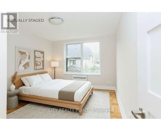 A bedroom with a bed, nightstand, and lamp.