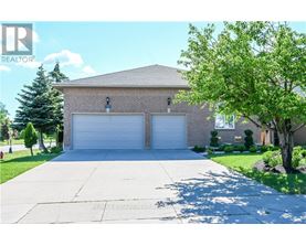 A house with a garage and a tree in front.