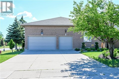 A house with a garage and a tree in front.