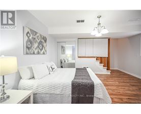 A bedroom with a large bed and a chandelier.