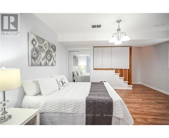 A bedroom with a large bed and a chandelier.