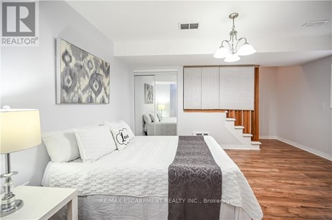 A bedroom with a large bed and a chandelier.