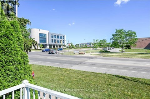 A view of a road with cars and a building in the background.