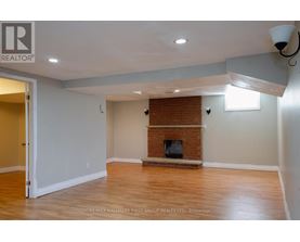 A room with a fireplace and a doorway leading to another room.