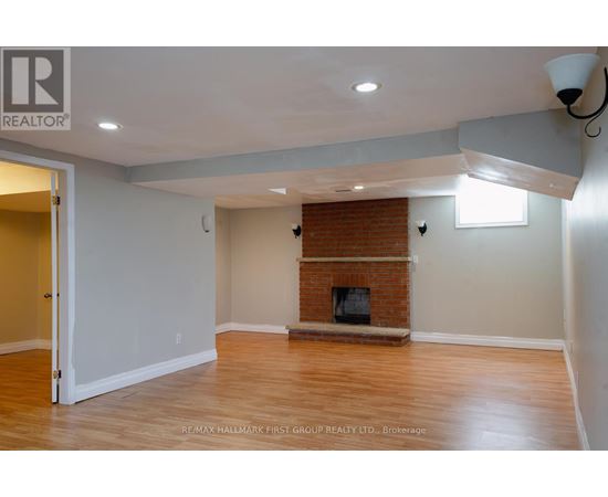 A room with a fireplace and a doorway leading to another room.