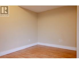 A room with a wooden floor and beige walls.