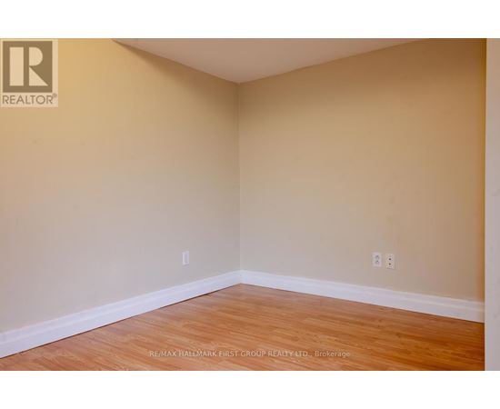 A room with a wooden floor and beige walls.