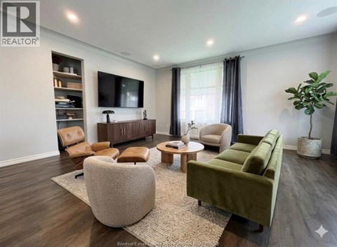 A living room with a green sofa and a wooden floor.