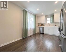 A kitchen with wooden floors and white cabinets.