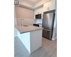 A modern kitchen with a stainless steel refrigerator and a white countertop.