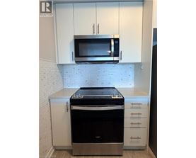 A modern kitchen with a stove and microwave above it.