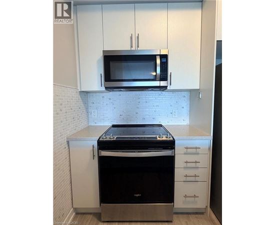 A modern kitchen with a stove and microwave above it.