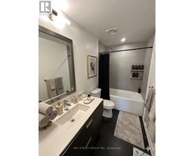 A bathroom with a white sink and a white toilet.