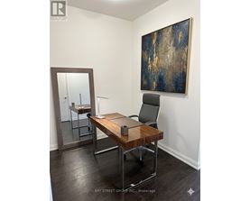 A room with a desk and a painting on the wall.