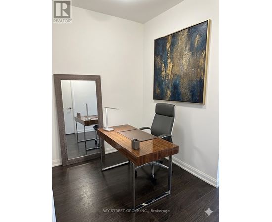 A room with a desk and a painting on the wall.
