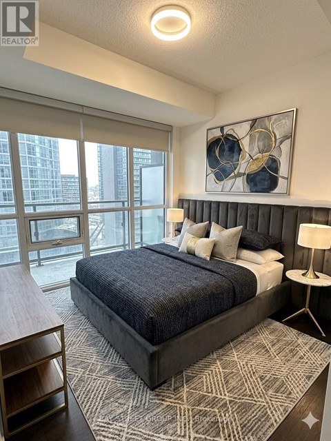 A bedroom with a large bed and a painting on the wall.