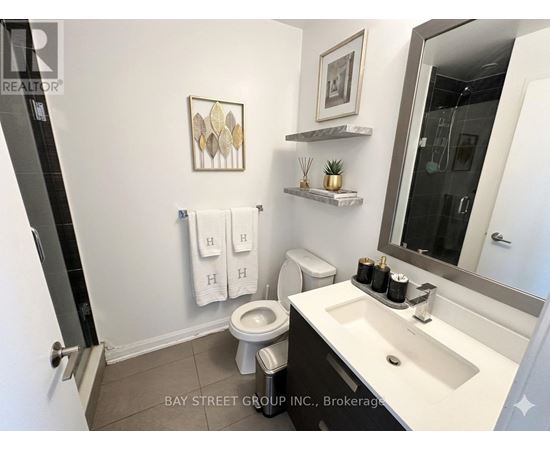 A bathroom with a toilet, sink, and mirror.