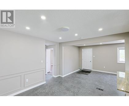 A spacious room with a marble floor and white walls.
