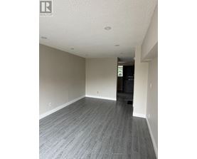 A spacious room with grey flooring and white walls.