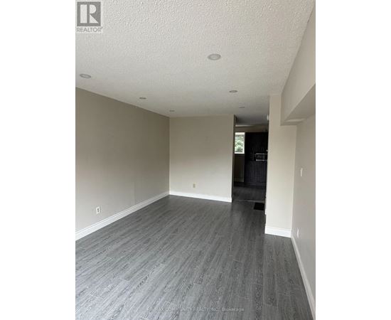 A spacious room with grey flooring and white walls.