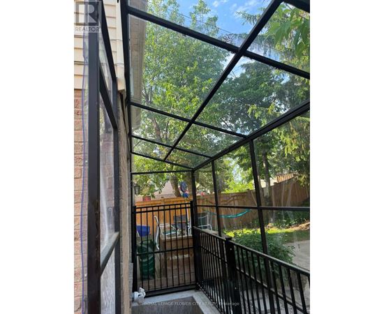 A balcony with a black railing and a view of a backyard.