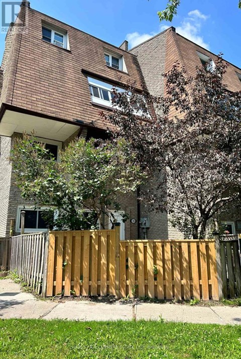 A brown building with a wooden fence in front of it.