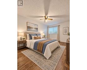 A bedroom with a bed, a ceiling fan, and a painting on the wall.