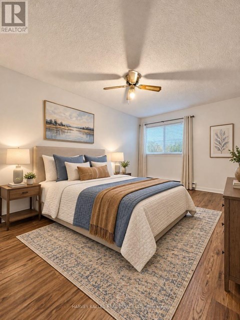 A bedroom with a bed, a ceiling fan, and a painting on the wall.