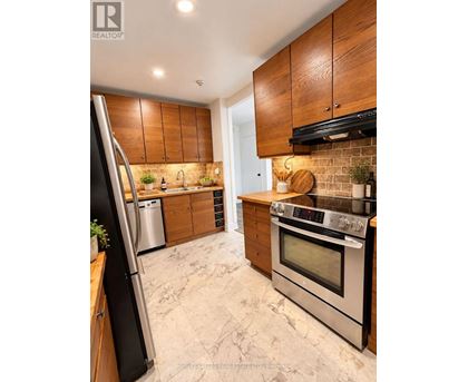 A modern kitchen with wooden cabinets and stainless steel appliances.