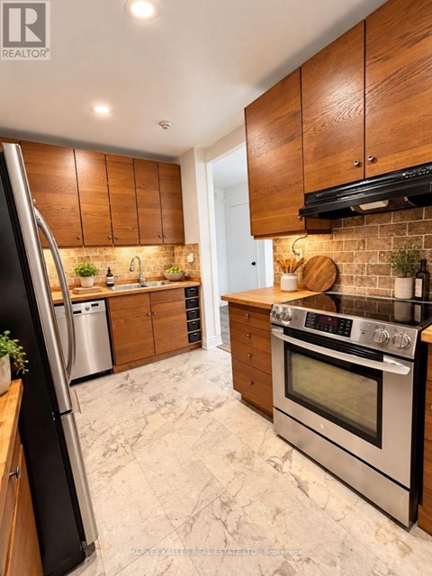 A modern kitchen with wooden cabinets and stainless steel appliances.