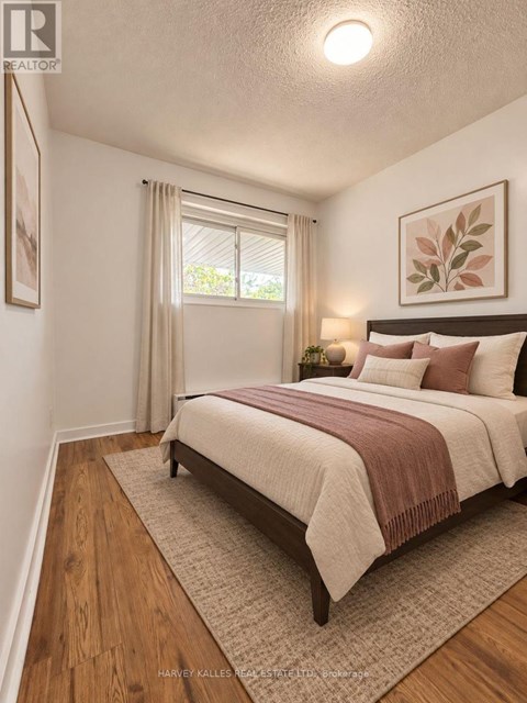 A bedroom with a large bed and a window with curtains.