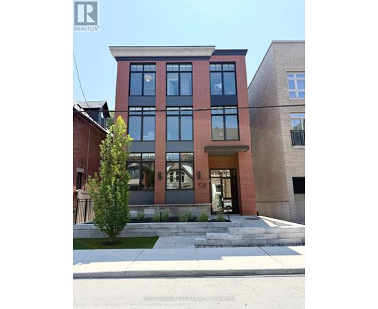A modern two story building with a red brick facade and large windows.