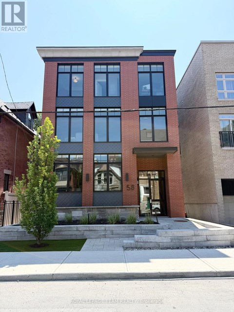 A modern two story building with a red brick facade and large windows.