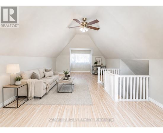A living room with a couch, a coffee table, and a ceiling fan.