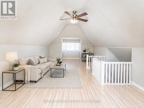 A living room with a couch, a coffee table, and a ceiling fan.