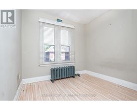 A room with a window and a radiator on the floor.