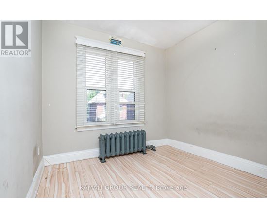 A room with a window and a radiator on the floor.