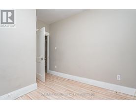 A room with a wooden floor and a white door.
