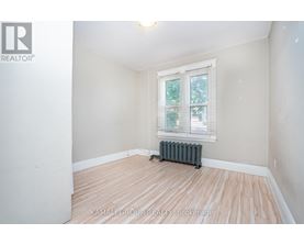 A room with a window and a radiator on the floor.