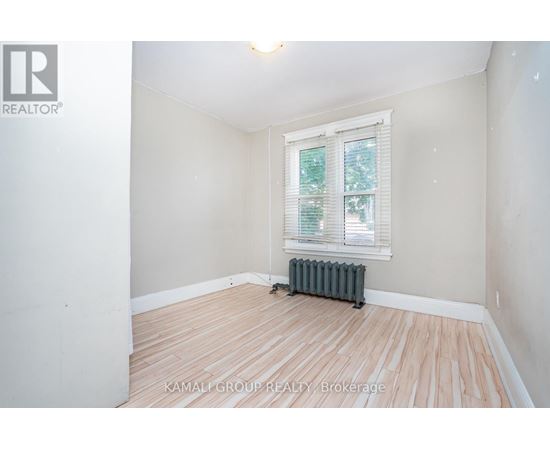 A room with a window and a radiator on the floor.