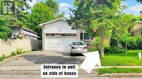 A car is parked in front of a house with a white arrow pointing to the entrance to a unit on the side of the house.