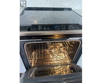An open oven with the door open showing the interior and rack.