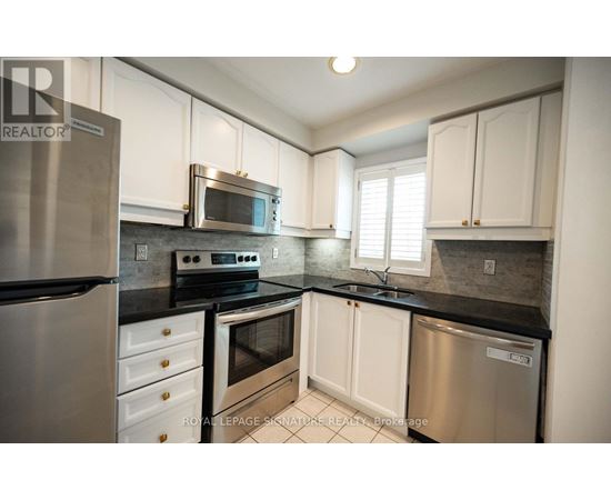 A kitchen with white cabinets and stainless steel appliances.