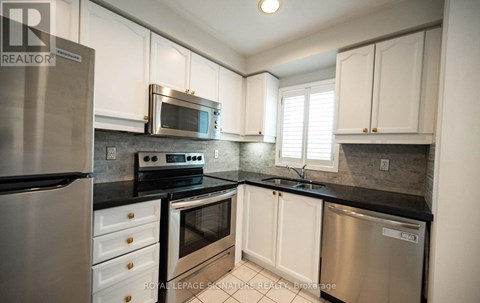 A kitchen with white cabinets and stainless steel appliances.
