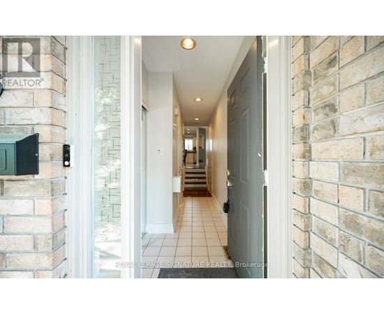 A hallway with a brick wall and a door on the right.