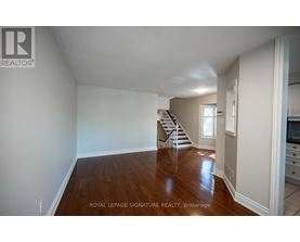A spacious room with wooden floors and white walls.