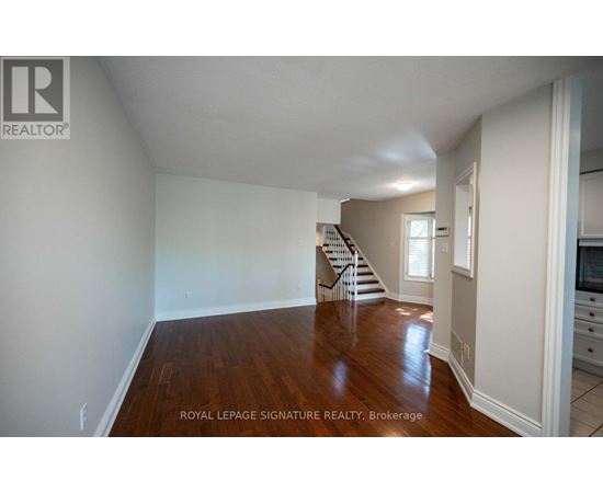 A spacious room with wooden floors and white walls.